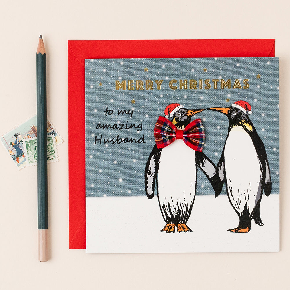 Christmas card with penguins and text 'Merry Christmas to my amazing Husband' on a red border.