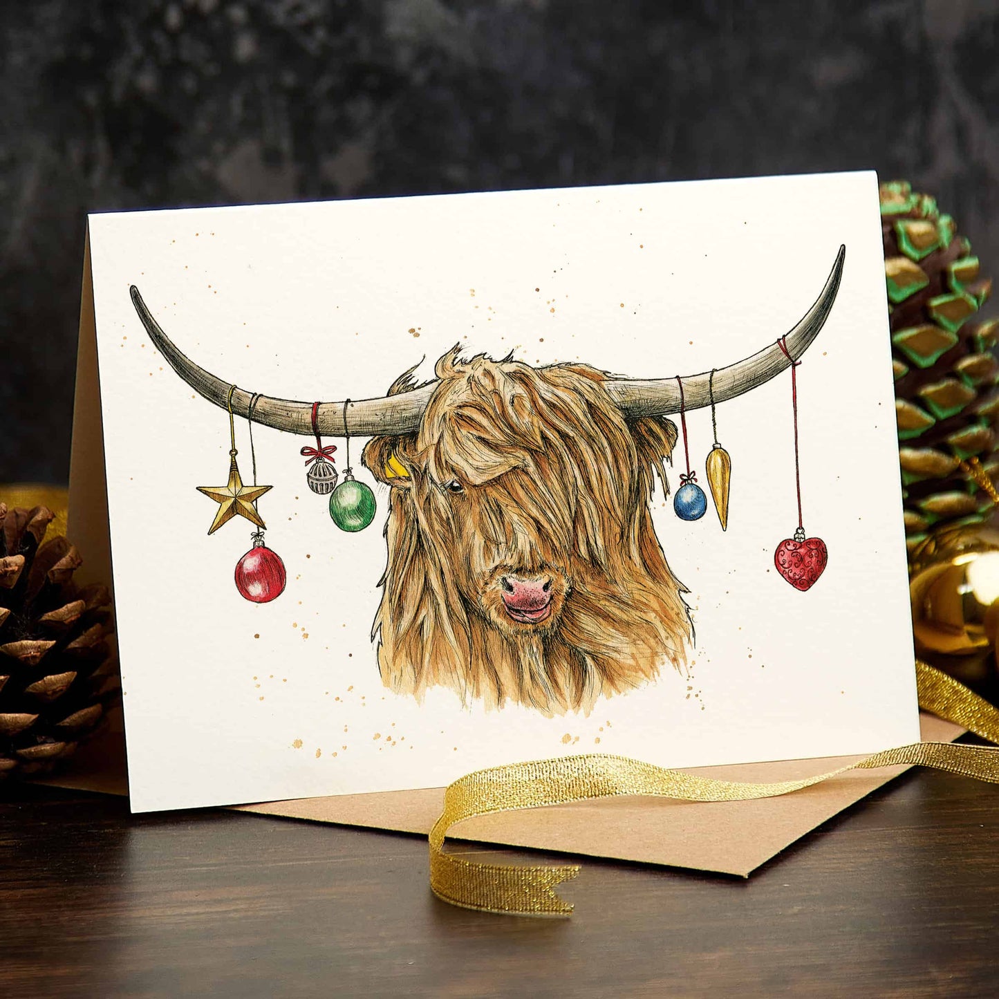 Greeting card with a highland cow illustration and Christmas ornaments, surrounded by festive decorations.