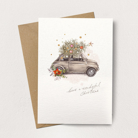 Greeting card with a vintage car carrying a Christmas tree and 'Have a wonderful Christmas' text, on a white background.