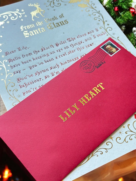 Letter from Santa Claus with red envelope labeled 'Lily Heart' on a festive background.